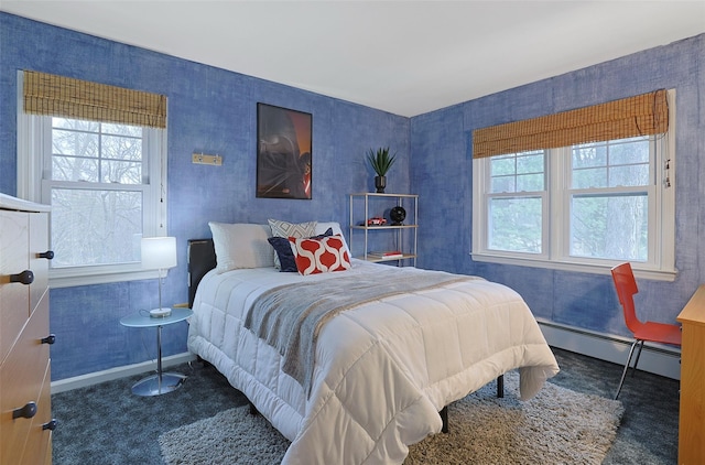 bedroom with multiple windows, baseboard heating, carpet floors, and baseboards