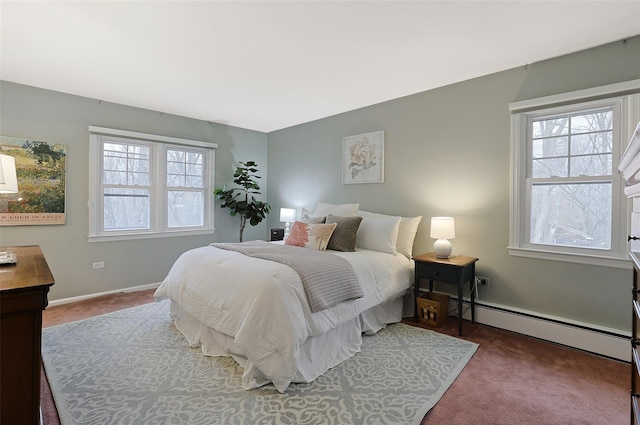 bedroom with a baseboard heating unit, multiple windows, and carpet flooring