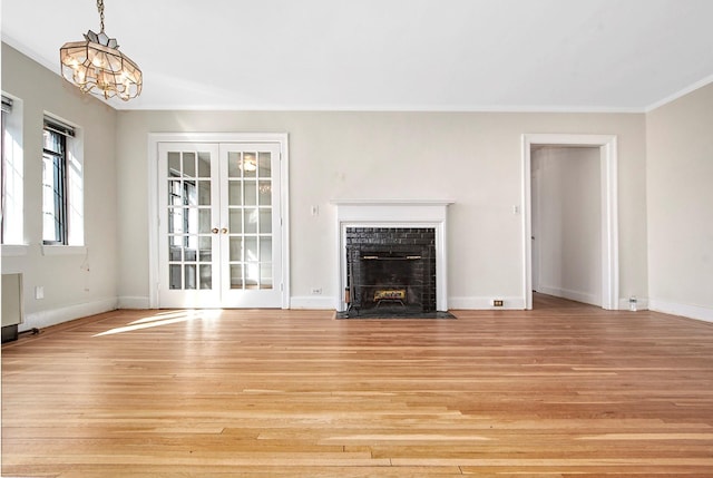 unfurnished living room featuring ornamental molding, a fireplace with flush hearth, and light wood-style floors