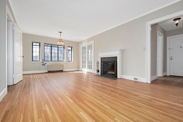 unfurnished living room with a fireplace, light wood-style flooring, ornamental molding, a chandelier, and baseboards