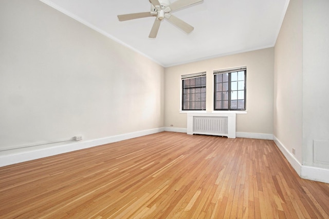 empty room featuring baseboards, ceiling fan, radiator heating unit, ornamental molding, and light wood-style flooring