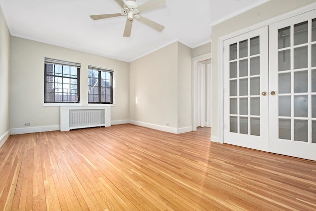 unfurnished room with crown molding, light wood finished floors, radiator, ceiling fan, and baseboards