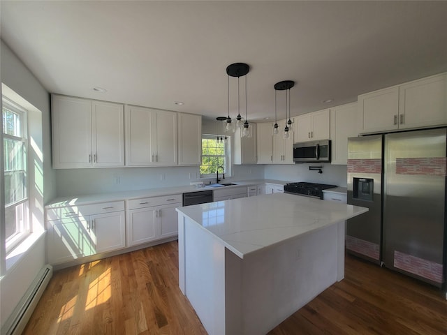 kitchen with a baseboard radiator, a kitchen island, appliances with stainless steel finishes, and white cabinets