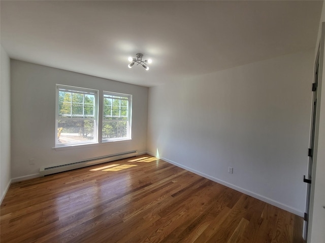 empty room featuring baseboard heating, dark wood finished floors, and baseboards