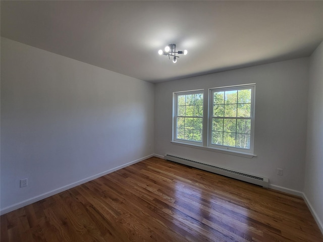 empty room featuring baseboards, baseboard heating, and dark wood finished floors