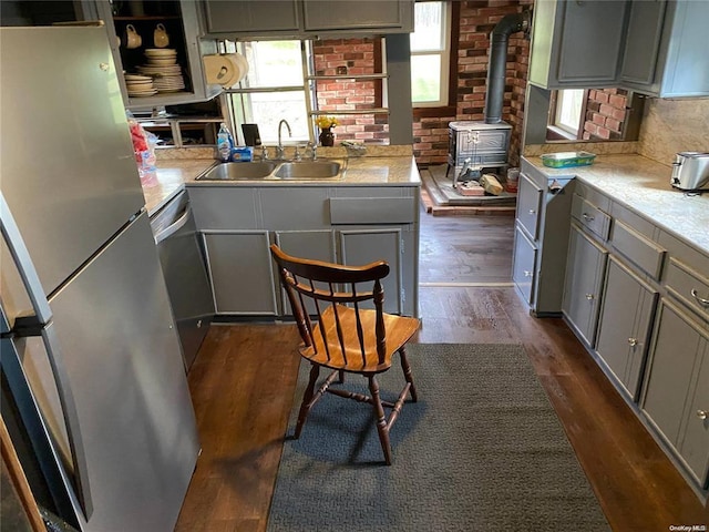 kitchen featuring light countertops, appliances with stainless steel finishes, gray cabinets, and a sink