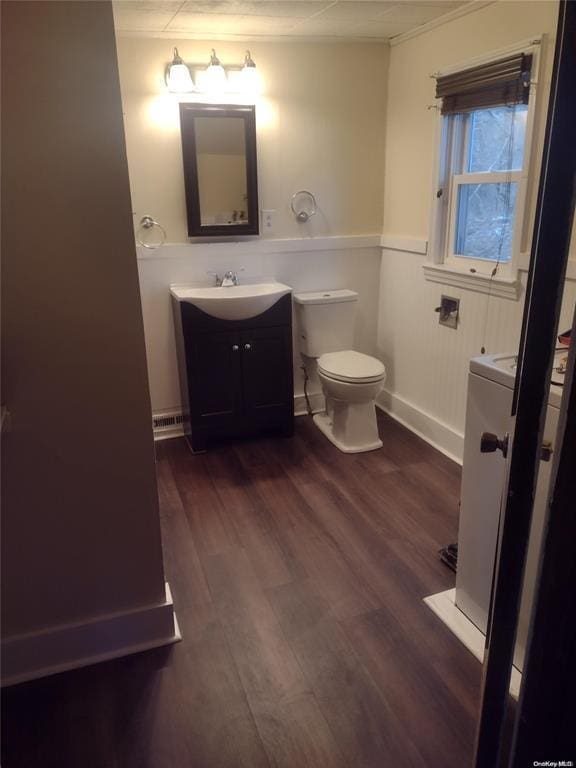 bathroom with crown molding, vanity, toilet, and wood finished floors