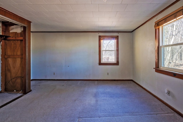 carpeted empty room with baseboards and crown molding