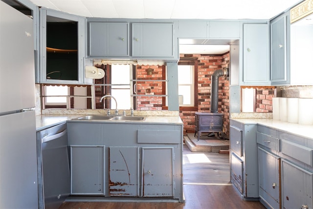 kitchen featuring dark wood-style flooring, gray cabinetry, stainless steel appliances, and a sink