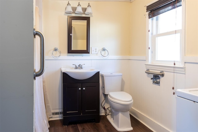bathroom with a wainscoted wall, toilet, vanity, and wood finished floors