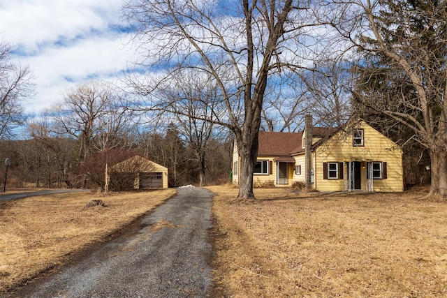 view of front of property with a garage, roof with shingles, and a chimney