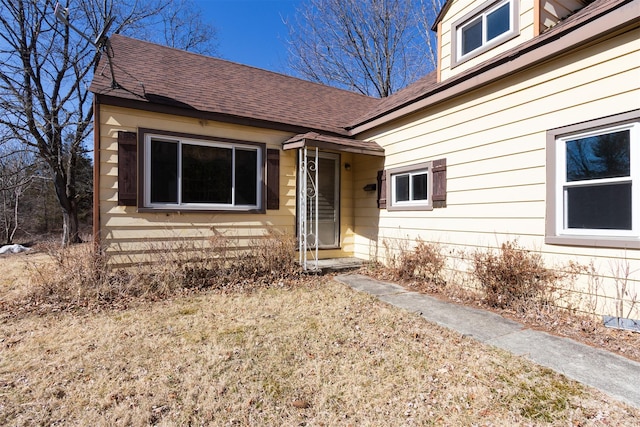 doorway to property with a shingled roof