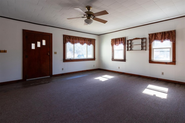 entrance foyer with carpet flooring, a ceiling fan, baseboards, and ornamental molding