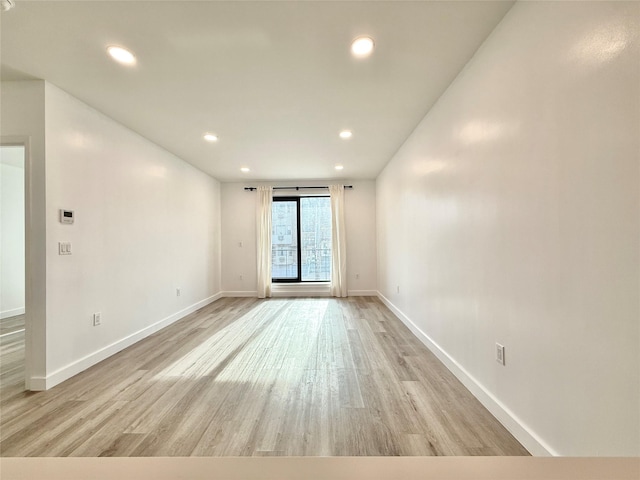 unfurnished room with light wood-type flooring, baseboards, and recessed lighting