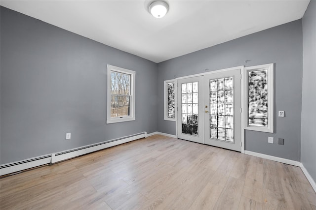 foyer entrance featuring light wood finished floors, french doors, a baseboard radiator, and baseboards