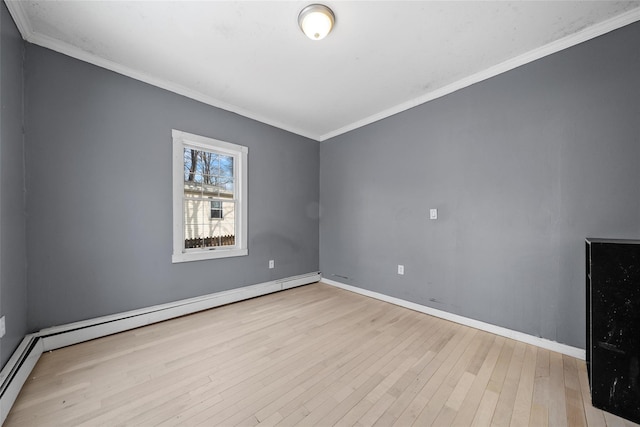 spare room featuring a baseboard heating unit, ornamental molding, and light wood-style floors