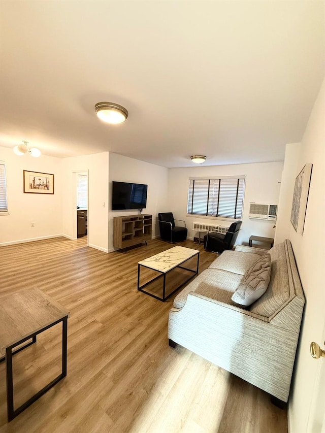 living area featuring light wood-style floors, radiator heating unit, and baseboards