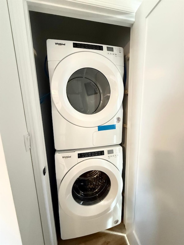 laundry room with stacked washer / drying machine and laundry area