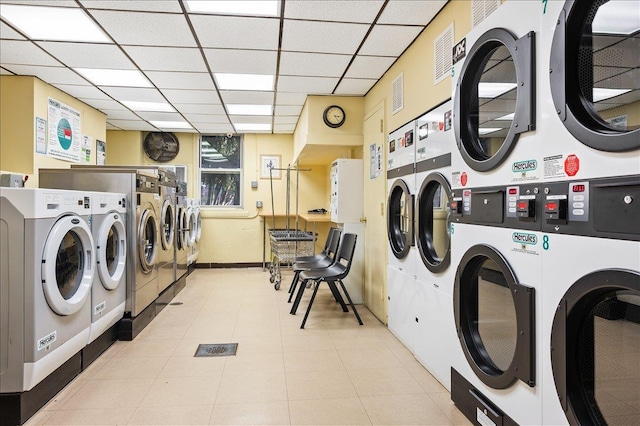 common laundry area featuring baseboards, washing machine and clothes dryer, visible vents, and stacked washer / drying machine