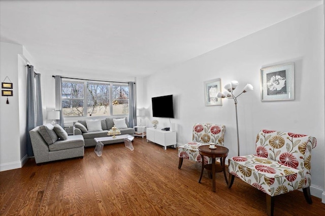 living area featuring dark wood-style flooring and baseboards