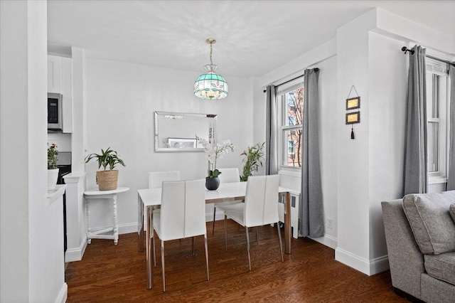 dining area with baseboards and wood finished floors