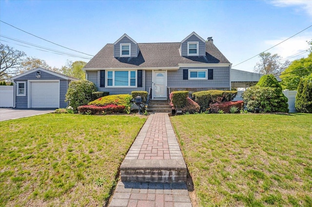 cape cod home featuring a detached garage, an outdoor structure, a chimney, and a front yard