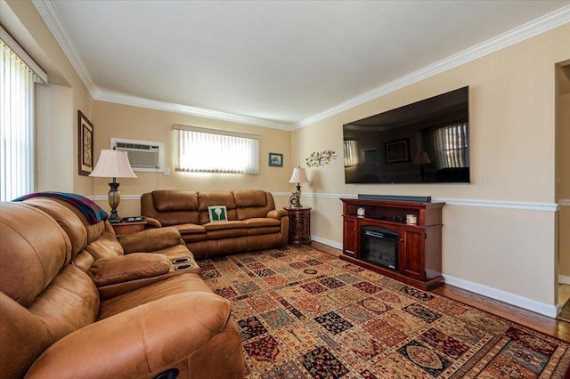 living room with a wall unit AC, crown molding, baseboards, a glass covered fireplace, and wood finished floors