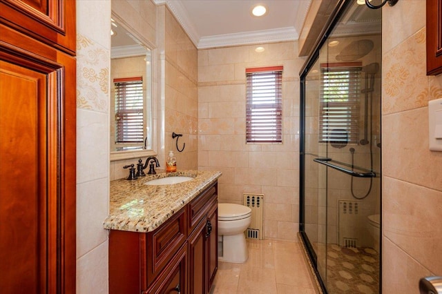 full bathroom featuring tile walls, toilet, crown molding, a shower stall, and vanity