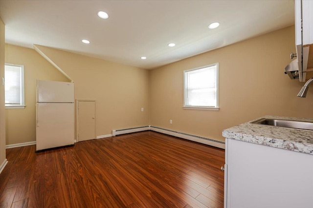 clothes washing area with baseboard heating, a sink, dark wood-style floors, recessed lighting, and baseboards