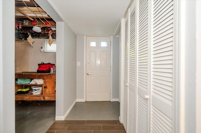 doorway featuring baseboards and wood finished floors