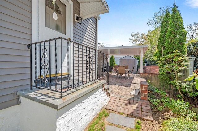 view of patio / terrace with a storage unit, outdoor dining area, and an outbuilding