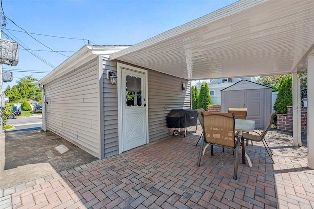 view of patio featuring outdoor dining area, an outdoor structure, and a shed