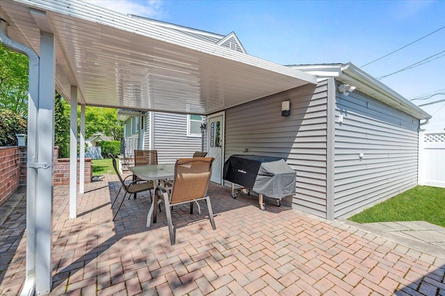 view of patio / terrace featuring a grill, outdoor dining space, and fence