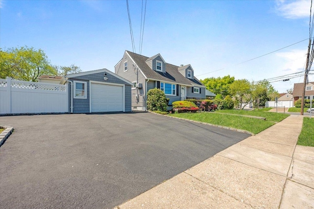 cape cod home featuring driveway and a garage