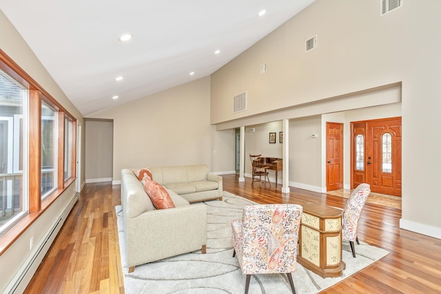 living room featuring visible vents, a baseboard heating unit, and baseboards