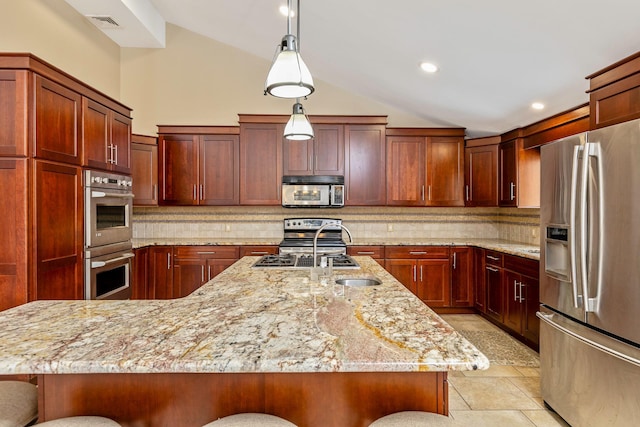 kitchen featuring vaulted ceiling, a center island with sink, stainless steel appliances, and a kitchen breakfast bar