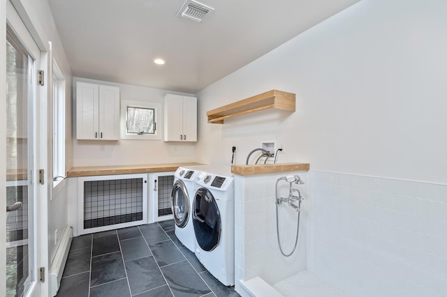 washroom with a baseboard radiator, recessed lighting, visible vents, independent washer and dryer, and cabinet space