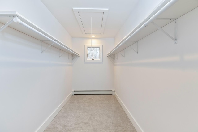 spacious closet featuring attic access, baseboard heating, and light colored carpet