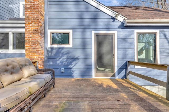 back of property featuring a deck and roof with shingles