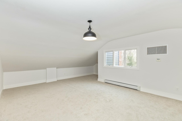 additional living space with light carpet, a baseboard radiator, visible vents, and baseboards