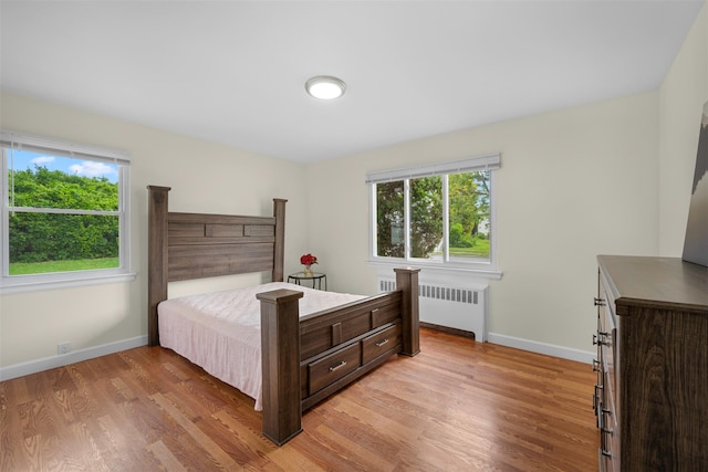 2057 Renfrew Ave, Elmont, NY 11003 - bedroom featuring radiator heating unit, multiple windows, and light wood-type flooring
