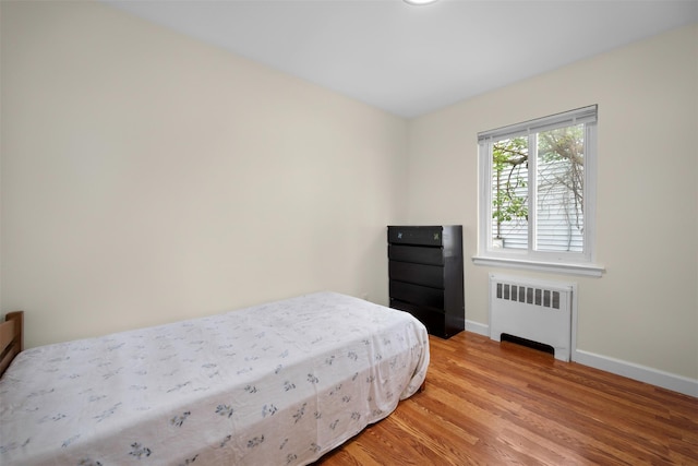 2057 Renfrew Ave, Elmont, NY 11003 - bedroom featuring radiator heating unit, baseboards, and light wood-type flooring