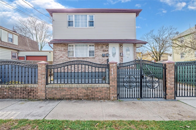 view of front facade featuring a fenced front yard, a gate, and brick siding