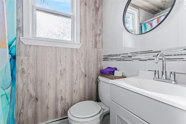 bathroom featuring tile walls, vanity, and toilet