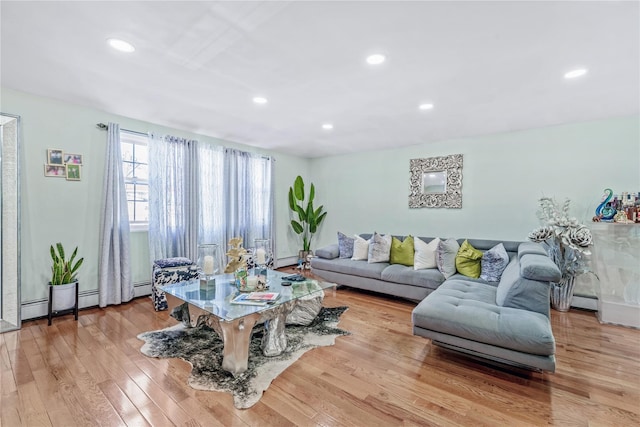 living room with a baseboard radiator, light wood-style flooring, and recessed lighting