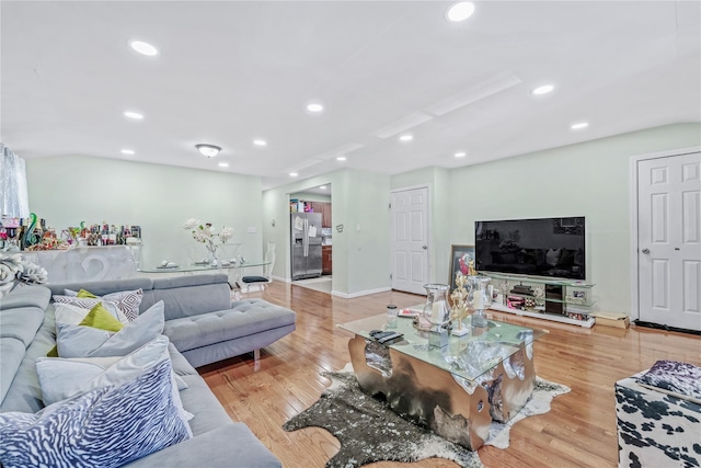 living area featuring baseboards, recessed lighting, and light wood-style floors