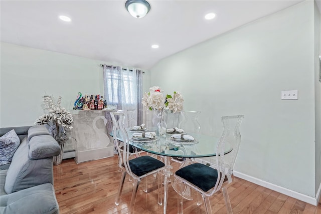 dining room featuring recessed lighting, a baseboard radiator, vaulted ceiling, wood finished floors, and baseboards