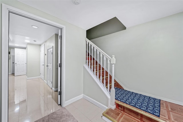 stairway featuring tile patterned flooring and baseboards