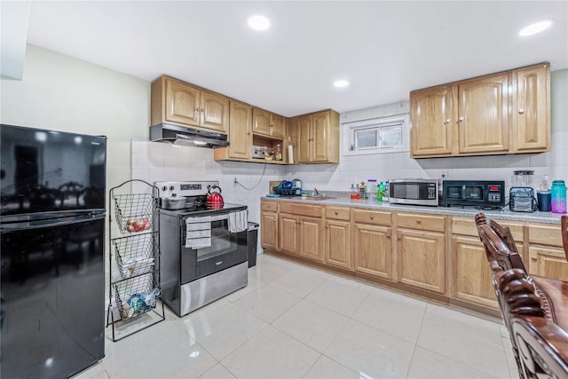 kitchen with tasteful backsplash, appliances with stainless steel finishes, light countertops, under cabinet range hood, and a sink