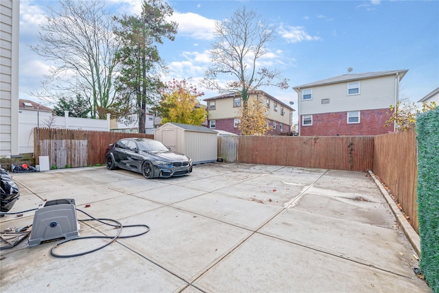 view of patio / terrace featuring an outbuilding, a fenced backyard, and a storage unit